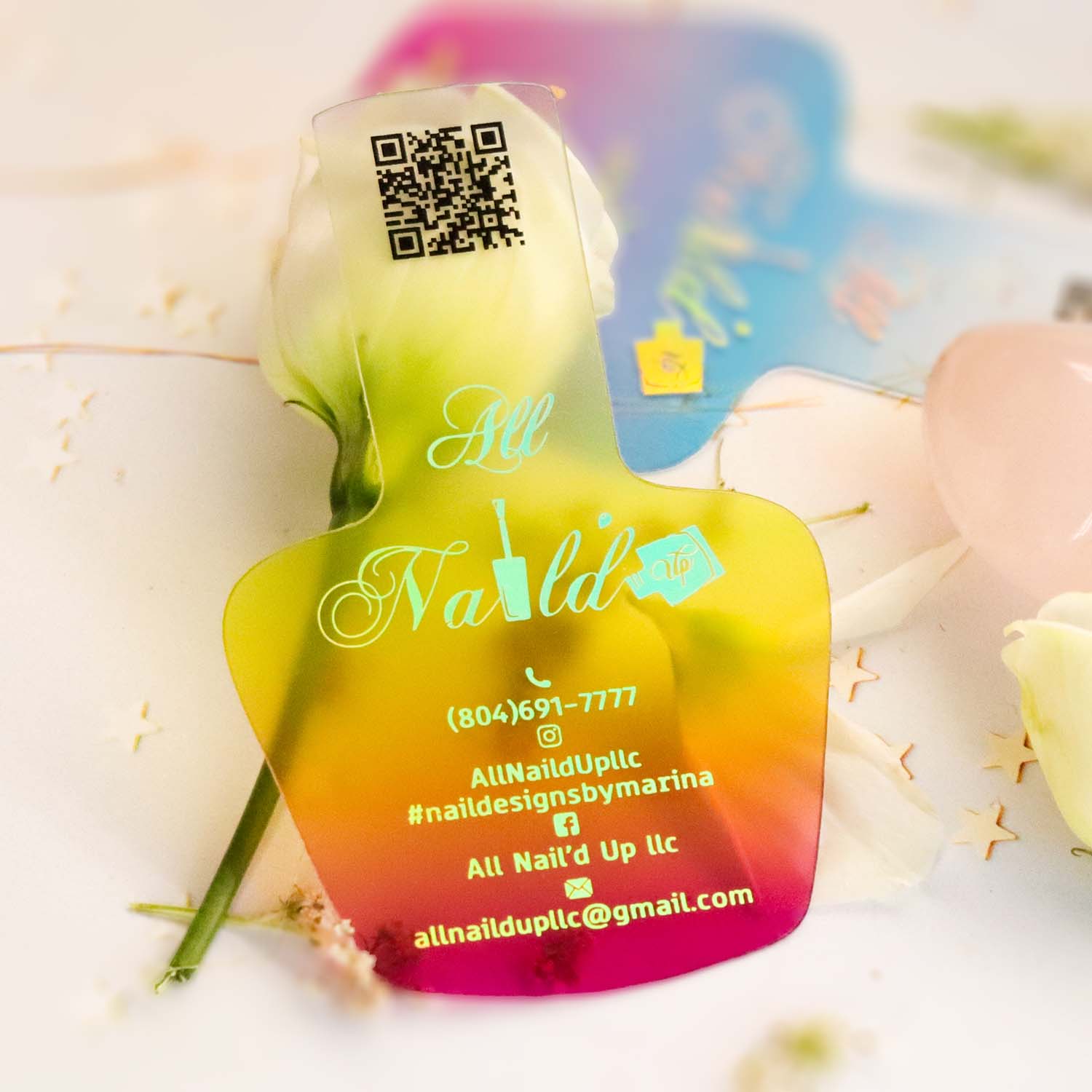 Colorful frosted business card with a QR code and contact information on a white background with flowers.