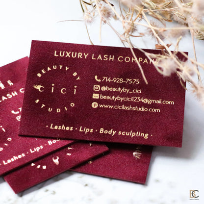 Collection of custom red velvet business cards with gold foil. Professional branding materials featuring deep red color and high-end tactile finish.