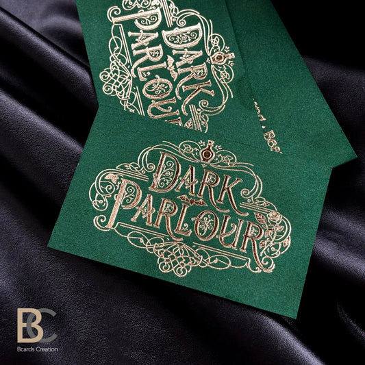 Close-up of gold foil debossing on deep green flocked paper, highlighting the rich fabric lint texture and metallic shine