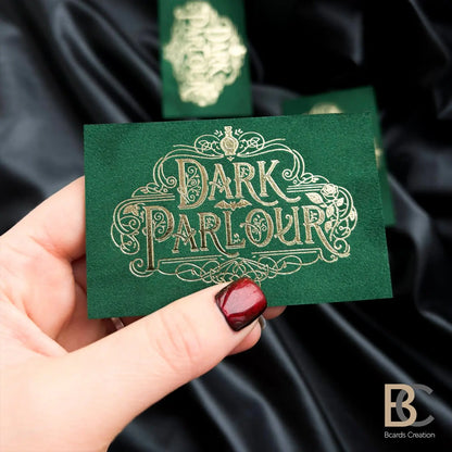 Multiple dark green velvet business cards with gold branding, showcasing the premium look and soft-touch fabric surface