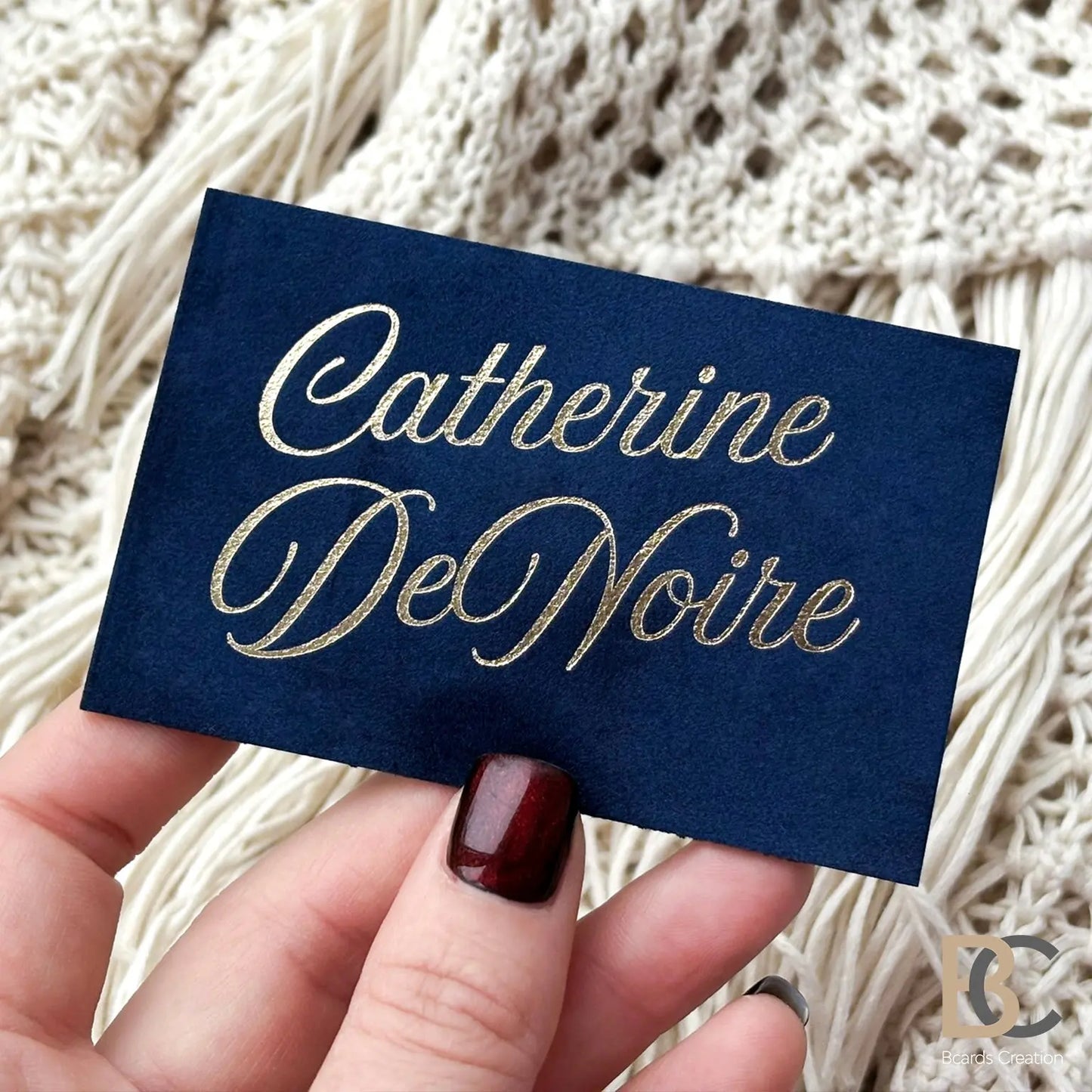 A professional holding The Royal Navy velvet card, demonstrating the 90x50 mm size and elegant light reflection on the gold.