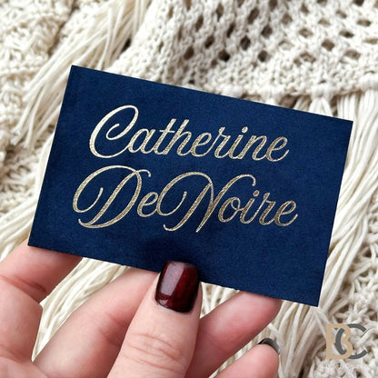 A professional holding The Royal Navy velvet card, demonstrating the 90x50 mm size and elegant light reflection on the gold.