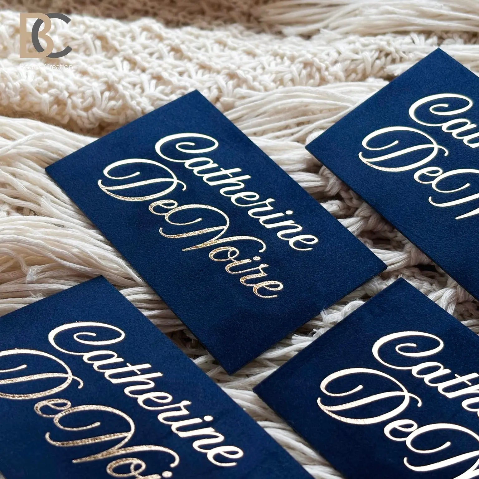 Collection of custom navy and gold business cards, showcasing the consistent fabric finish and luxury branding aesthetic.